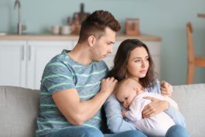 Femme avec son bébé et son mari ayant subit une erreur médicale à l’accouchement